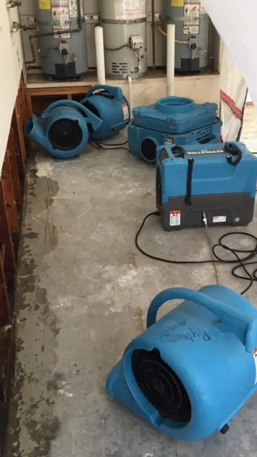 Air movers and a dehumidifier drying a room to a verified standard in Kannapolis, NC